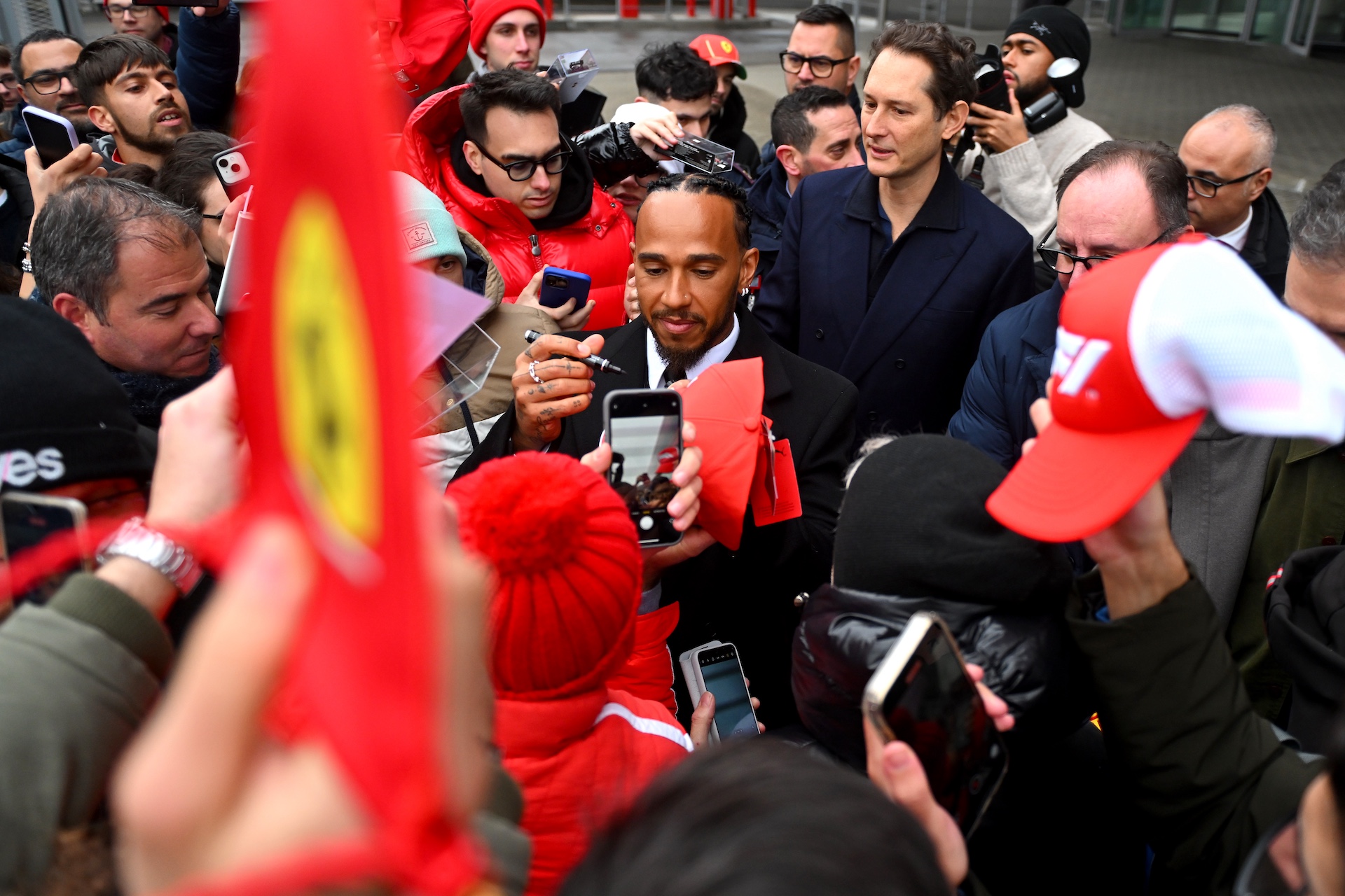 FIORANO MODENESE, ITALY - JANUARY 20: Sir Lewis Hamilton greets fans during his first official days as a Scuderia Ferrari F1 driver at Fiorano Circuit as John Elkann, CEO of Exor, looks on, on January 20, 2025 in Fiorano Modenese, Italy. (Photo by Rudy Carezzevoli/Getty Images)