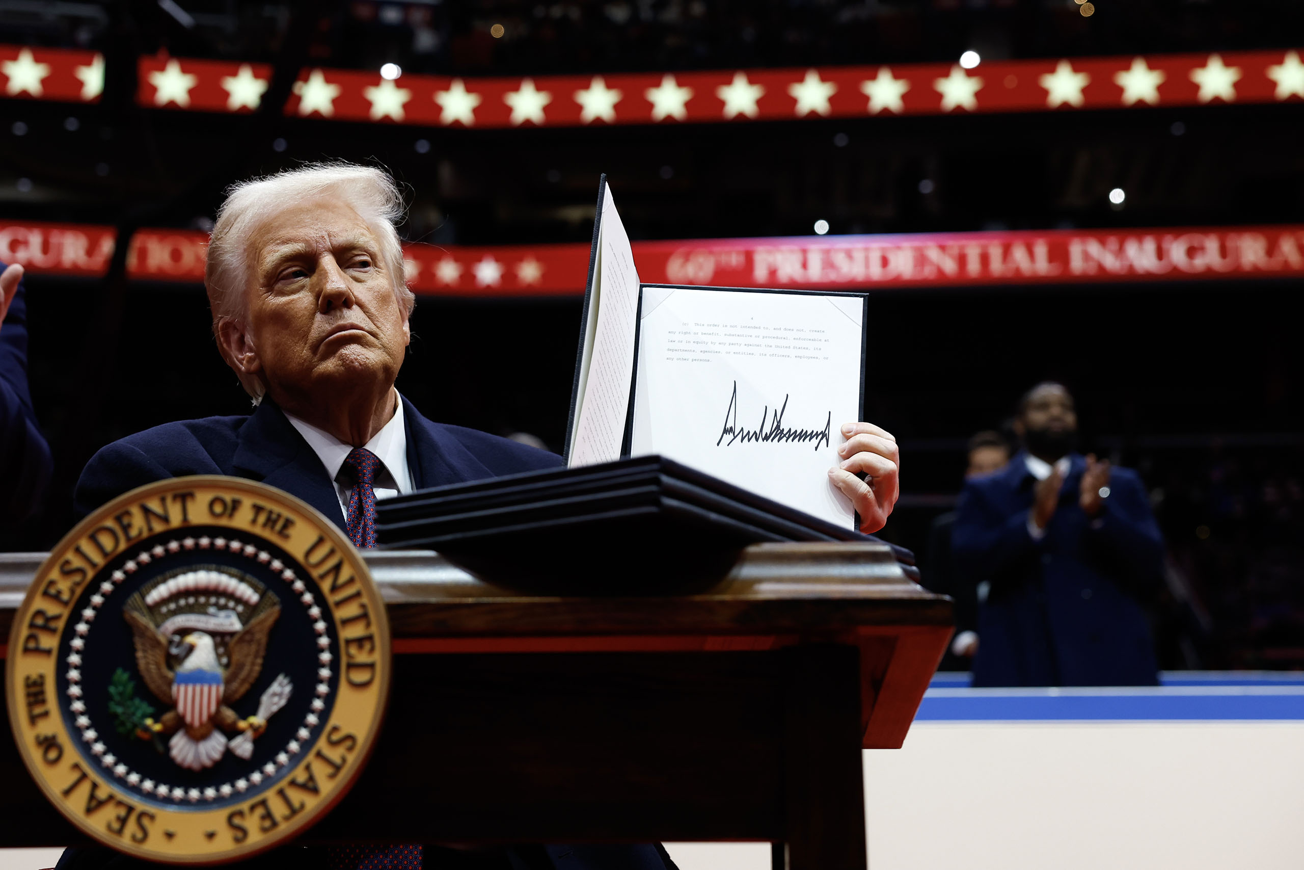 WASHINGTON, DC - JANUARY 20: U.S. President Donald Trump holds up an executive order after signing it during an indoor inauguration parade at Capital One Arena on January 20, 2025 in Washington, DC. Donald Trump takes office for his second term as the 47th president of the United States. (Photo by Anna Moneymaker/Getty Images)