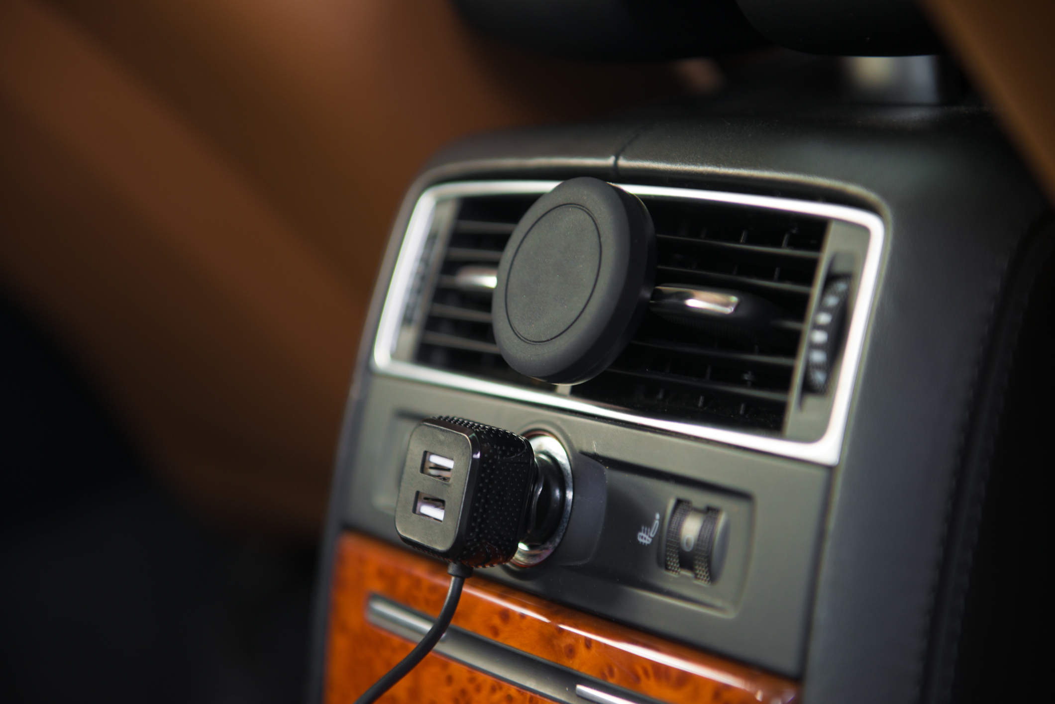 A car charger plugged into the cigarette lighter of a vehicle. 