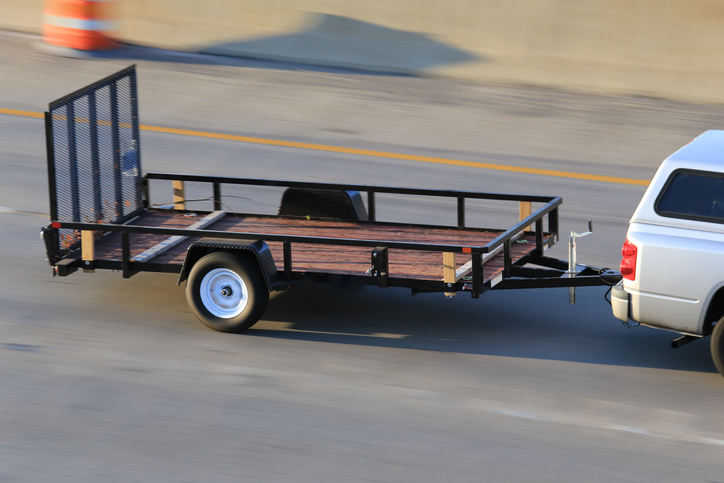 A car pulling a trailer on a highway.