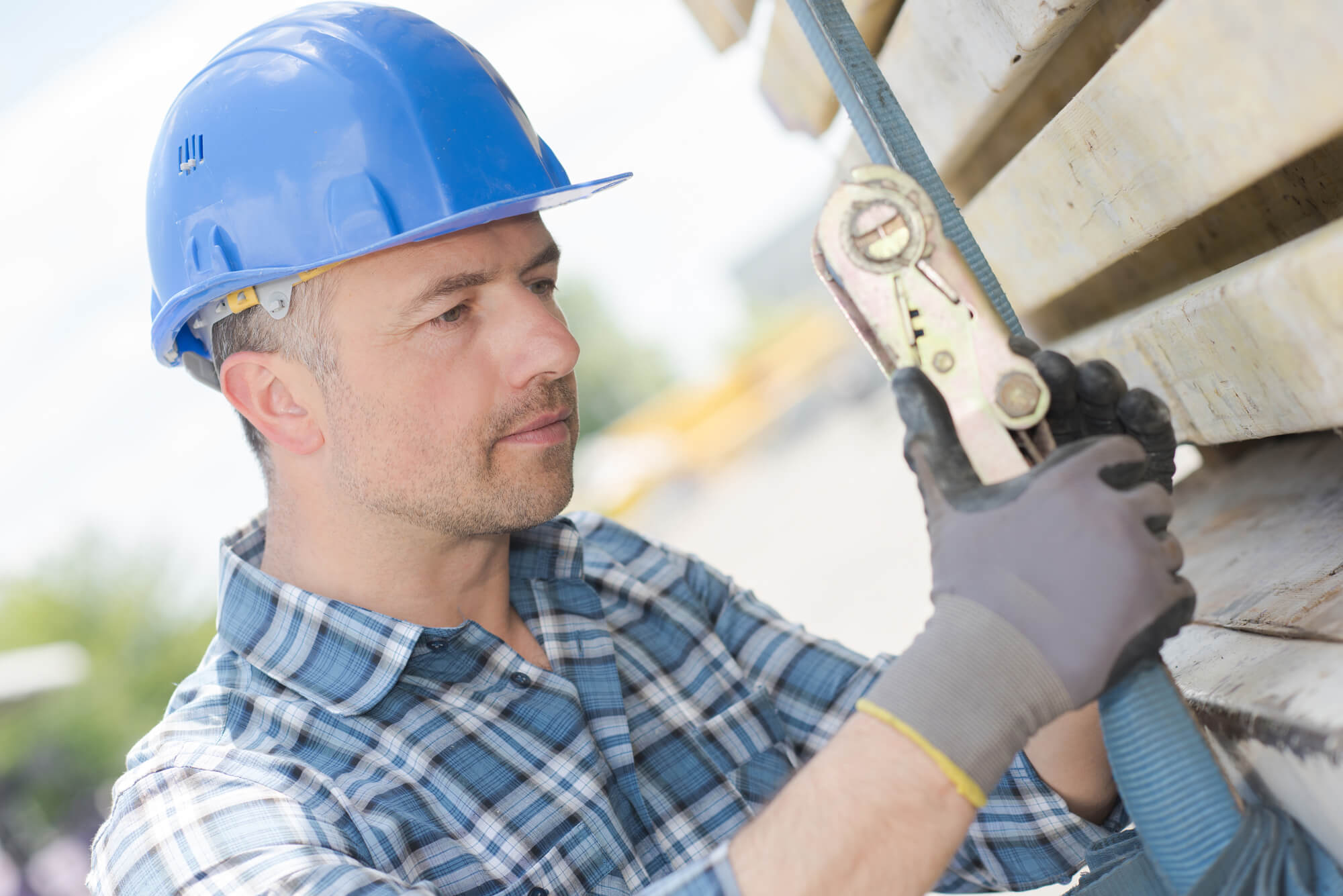 Man attaching load with ratchet strap