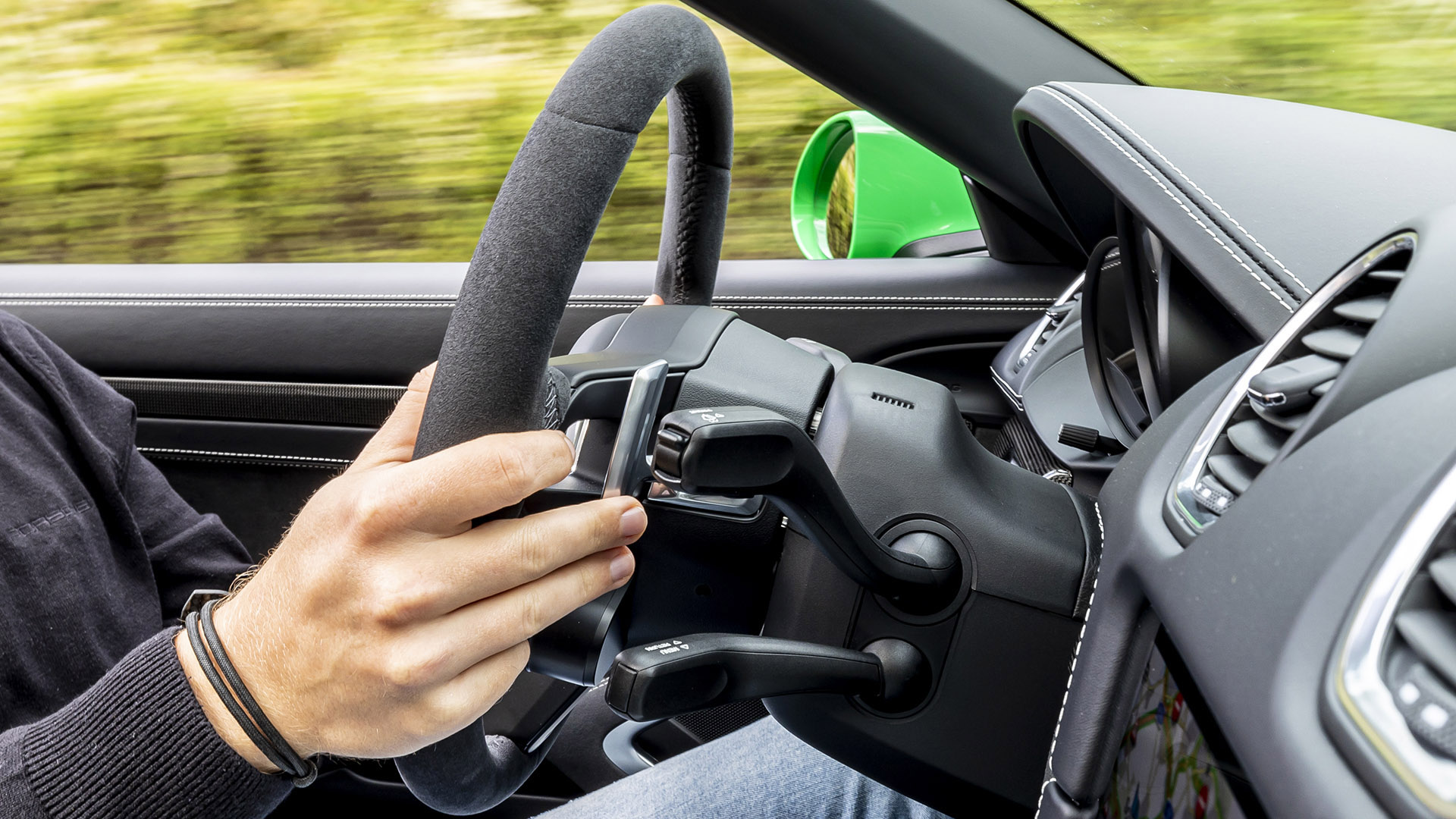 A driver uses the right-hand paddle shifter in a Porsche 911.