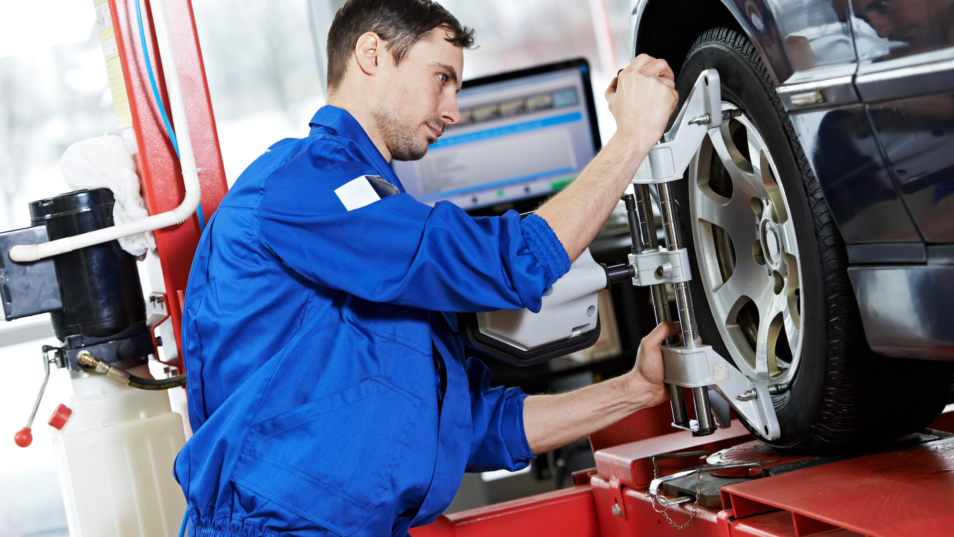 A mechanic sets up a wheel alignment.