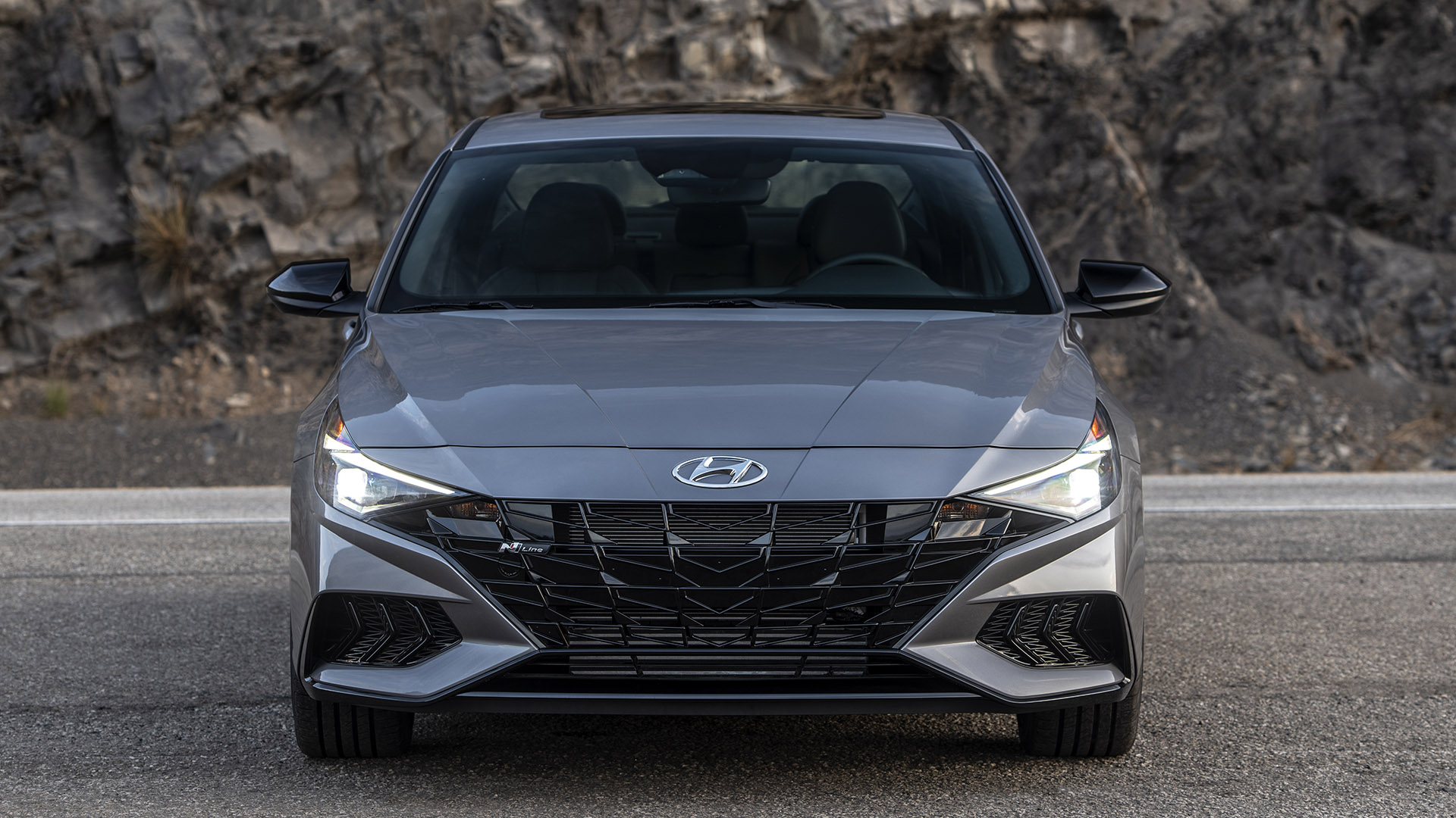 A gray Hyundai Elantra sits on a canyon road facing the camera.