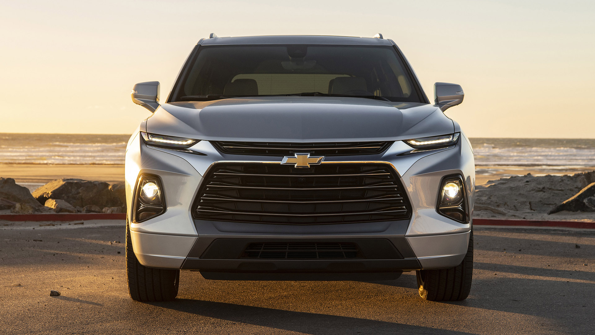 A silver 2019 Chevrolet Blazer shows its HID headlights at the beach.