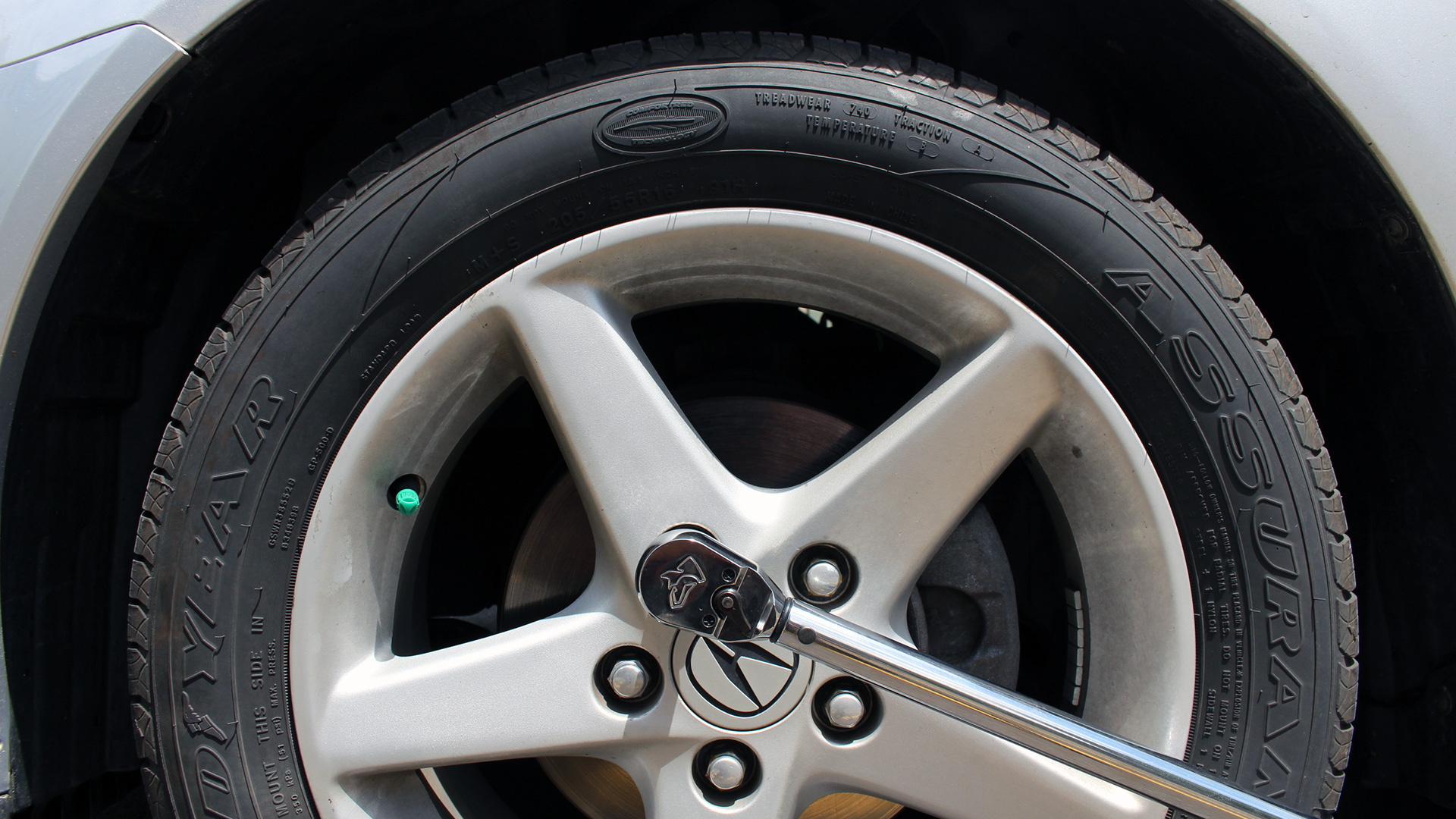 A Husky Torque Wrench with a 1/2-inch drive is used on a 2003 Acura RSX to tighten the lug nuts.